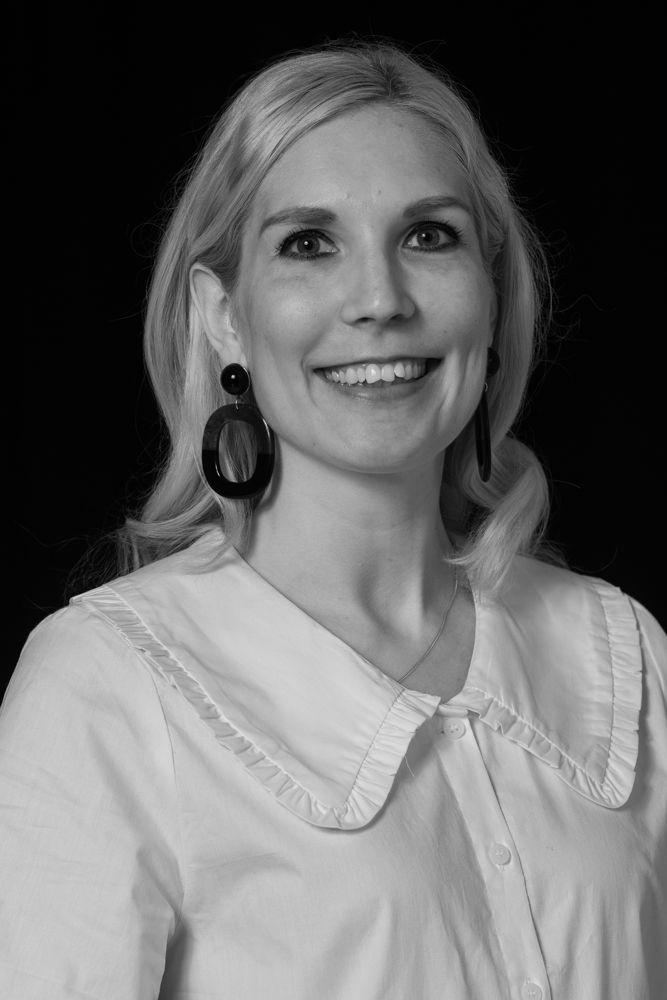 A picture of a woman smiling in a black and white photo.