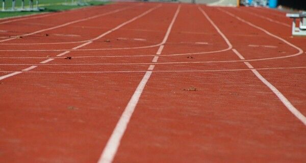 Punainen juoksurata tyhjällä stadionilla.